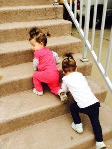 two young girls climbing up carpeted steps