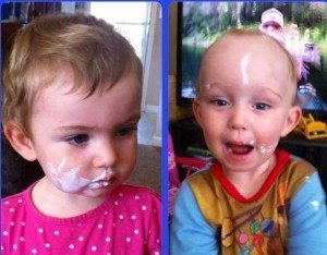 two young kids with yogurt on their faces