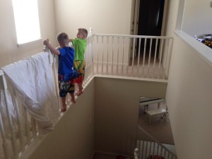two boys climbing on a stair railing