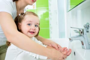 girl washing her hands potty training twins